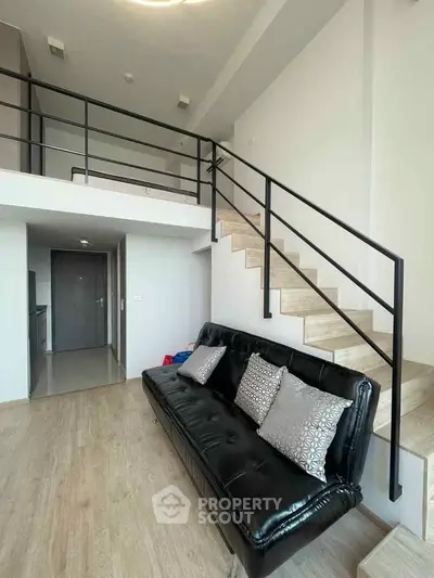 Modern loft apartment with sleek staircase and stylish black sofa