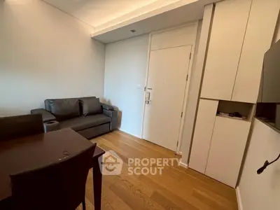 Modern living room with sleek furniture and wooden flooring in a contemporary apartment.