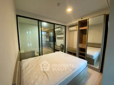 Modern bedroom with glass partition and built-in wardrobe in a stylish apartment.