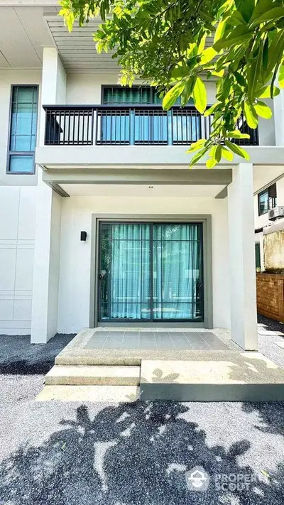 Modern two-story house exterior with balcony and large windows