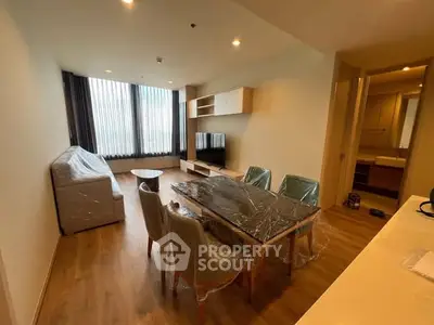 Modern furnished living room with dining area and large window view