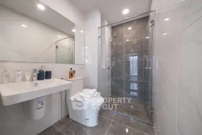 Luxurious modern bathroom with sleek glass shower and elegant marble tiles