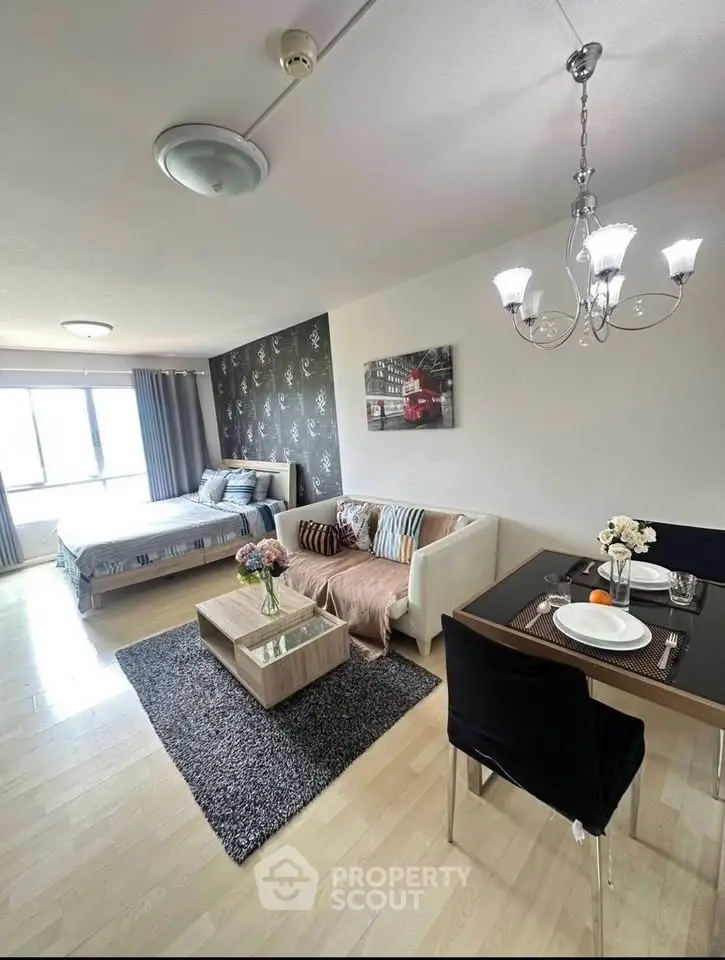 Spacious studio apartment with modern decor, featuring a cozy bed, stylish sofa, and elegant dining area.
