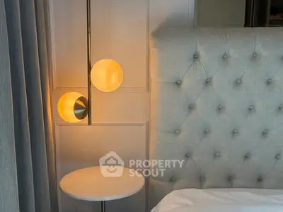 Elegant bedroom corner with tufted headboard and modern lighting