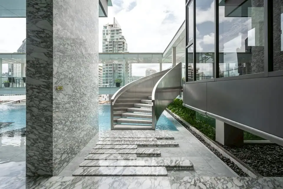 Luxurious modern building with stunning pool and city view, featuring elegant marble design and sleek architecture.