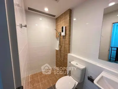 Modern bathroom with sleek design and efficient layout, featuring a shower and contemporary fixtures.