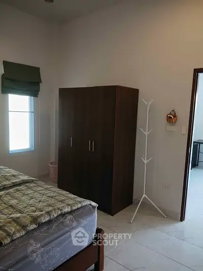 Cozy bedroom with wardrobe and window, perfect for comfortable living.