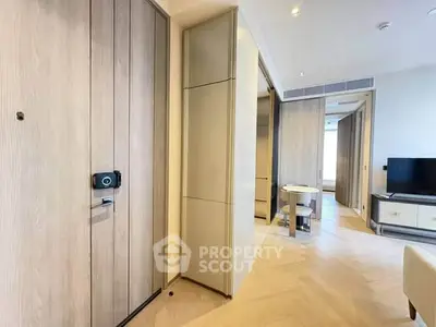Modern apartment interior with wooden flooring and sleek design, featuring a TV and dining area.