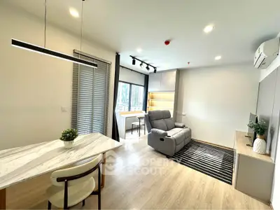 Modern living room with sleek furniture and natural light, featuring a cozy seating area and stylish decor.