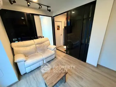 Modern living room with sleek glass partitions and cozy beige sofa