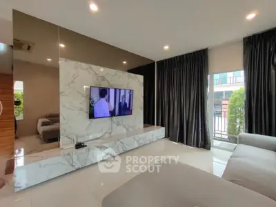 Luxurious modern living room with marble TV wall and plush seating, perfect for relaxation.
