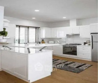 Modern white kitchen with gas stove and sleek cabinetry