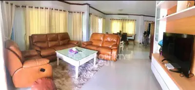 Spacious living room with leather sofas and modern entertainment center