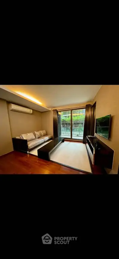 Modern living room with sleek furniture and large window offering a garden view, perfect for relaxation.