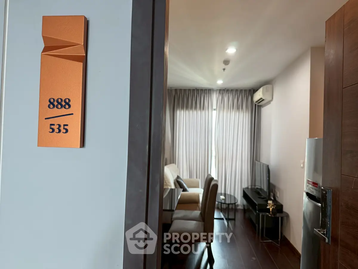 Modern apartment entrance with stylish interior, featuring a cozy living room and dining area.