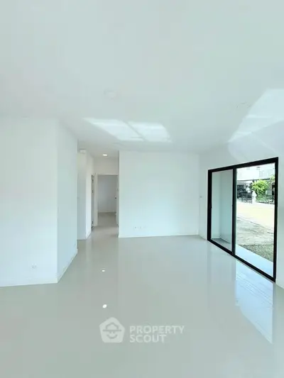 Spacious modern living room with large windows and glossy white tiles