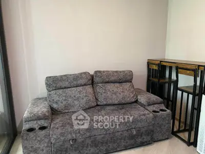 Modern living room with stylish grey sofa and bar stools