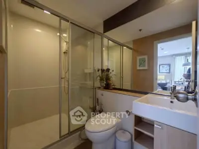 Modern bathroom with glass shower and sleek fixtures in a stylish apartment.