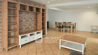 Spacious living room with modern wooden furniture and dining area, perfect for family gatherings.