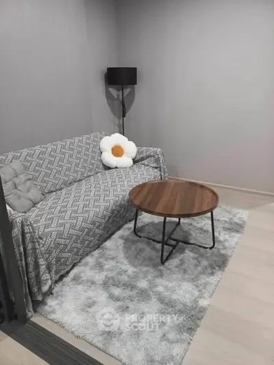 Cozy living room with stylish sofa, modern lamp, and chic round coffee table on plush rug.