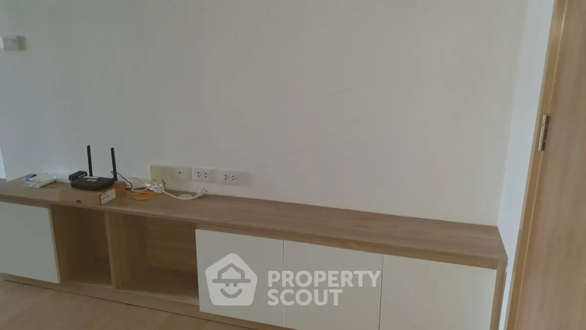 Minimalist living room with wooden cabinet and modern router setup.