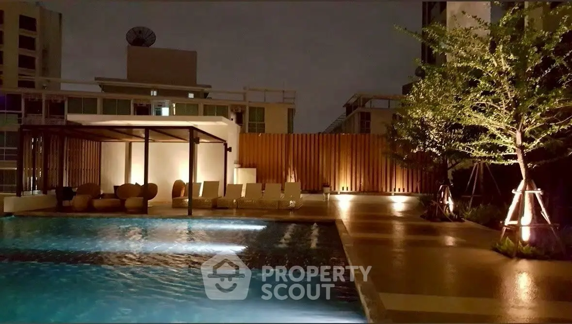 Luxurious night view of a modern apartment pool area with ambient lighting.