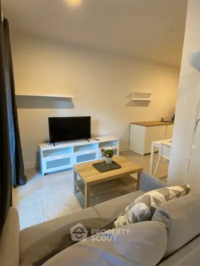 Cozy living room with modern decor and compact TV setup, perfect for urban living.