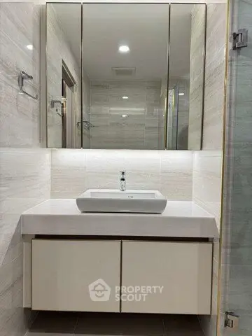 Modern bathroom with sleek vanity and mirrored cabinet in a stylish apartment.
