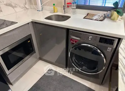 Modern kitchen with integrated appliances including a washing machine and microwave, sleek countertops, and stylish decor.