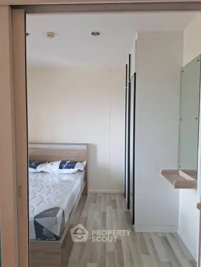 Modern bedroom with wooden flooring and minimalist design in a stylish apartment.