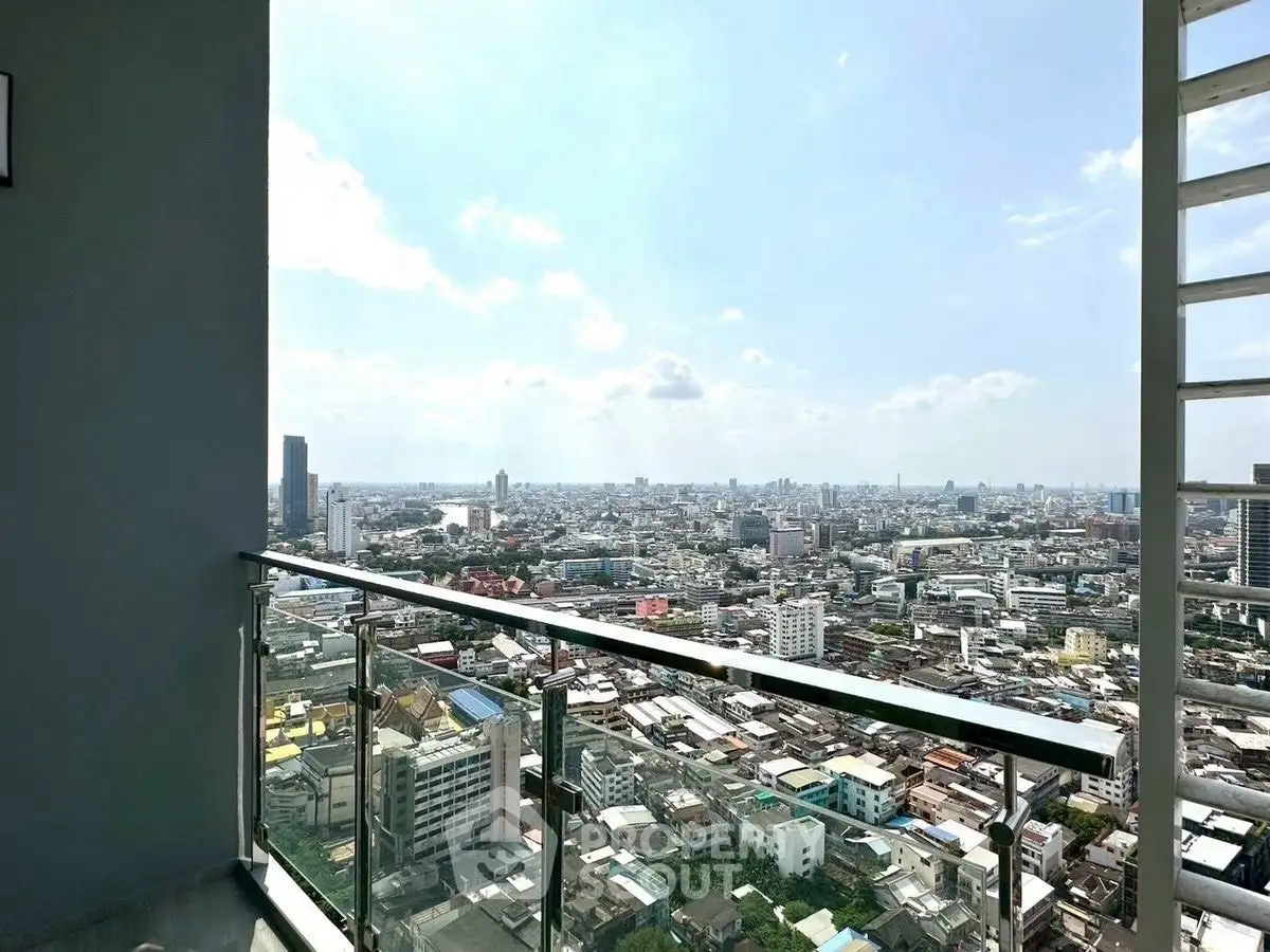 Stunning cityscape view from a high-rise balcony with glass railing.