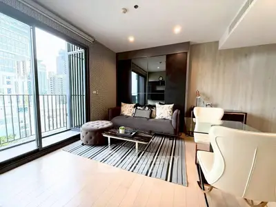 Modern living room with stylish decor and city view balcony in luxury apartment.