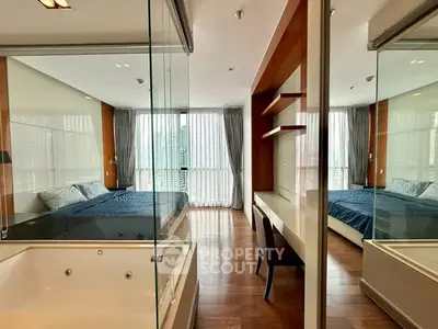 Luxurious bedroom with glass walls and city view, featuring a modern bathtub and elegant decor.