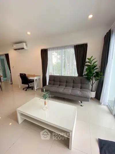 Modern living room with sleek furniture and natural light, perfect for relaxation and productivity.