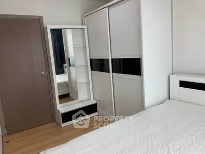 Modern bedroom with sleek white furniture and ample storage space