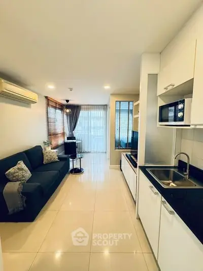 Modern open-layout living room and kitchen with sleek design and natural light.
