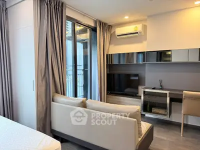 Modern living room with sleek furniture and balcony access in a stylish apartment.