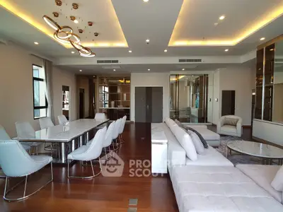 Luxurious open-plan living room with elegant dining area and modern lighting fixtures.
