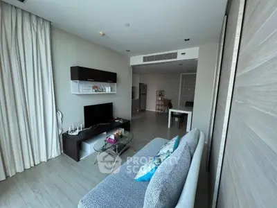 Modern living room with sleek furniture and open layout, featuring a cozy sofa and stylish TV unit.