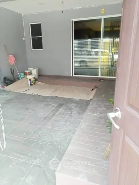 Spacious entrance area with sliding glass doors and tiled flooring