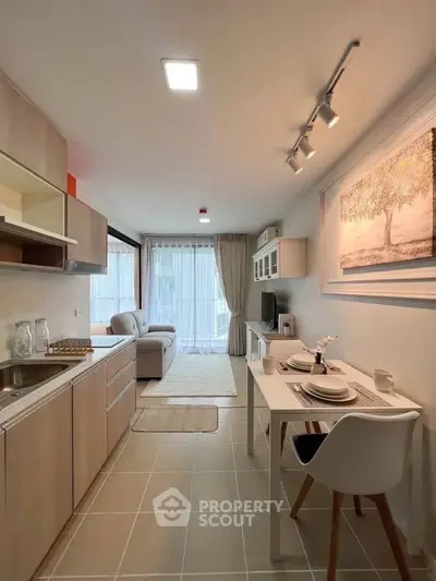 Modern open-plan kitchen and living area with stylish decor and natural light.
