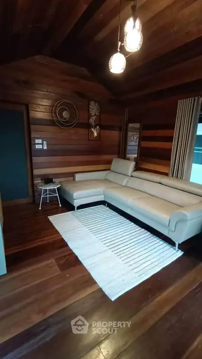 Cozy living room with wooden walls and modern beige sectional sofa