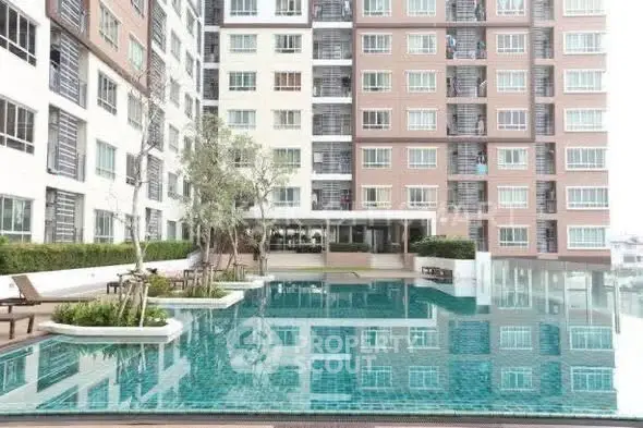 Modern condominium with a stunning outdoor pool and lush greenery, perfect for urban living.
