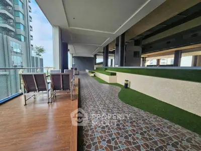 Spacious modern balcony with stylish flooring and seating area in luxury apartment complex.