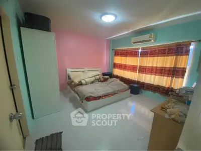 Cozy bedroom with colorful walls and air conditioning, perfect for a comfortable living experience.