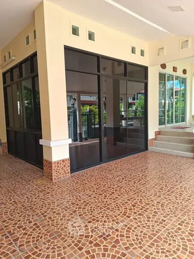 Spacious tiled patio with modern glass doors and elegant design.