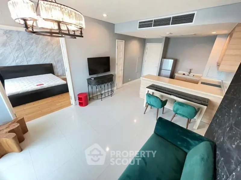 Modern open-plan living room with stylish kitchen and cozy bedroom area.