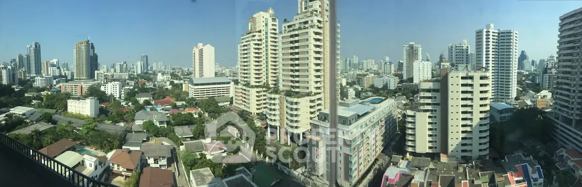 Stunning panoramic cityscape view from a high-rise balcony showcasing urban skyline and residential buildings.