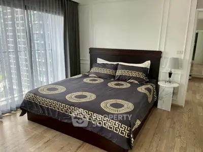 Elegant bedroom with stylish bedding and city view from large window