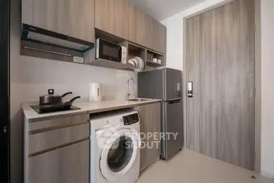 Modern compact kitchen with washing machine and stainless steel appliances